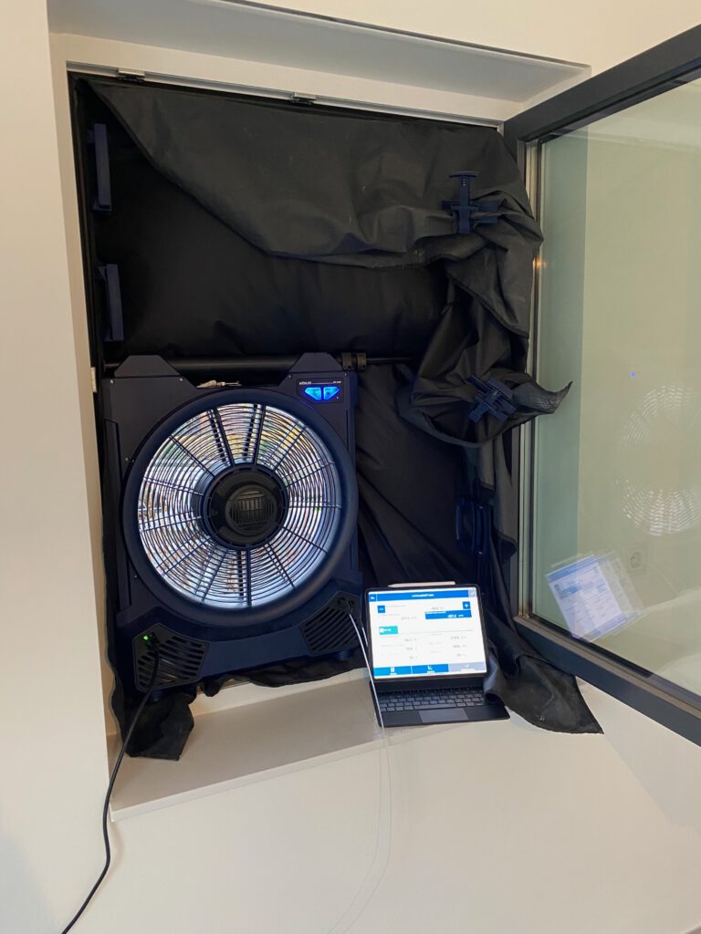 Professioneller Blower-Door-Test mit Messventilator und Laptop zur Luftdichtheitsmessung – Was kostet ein Blower-Door-Test?