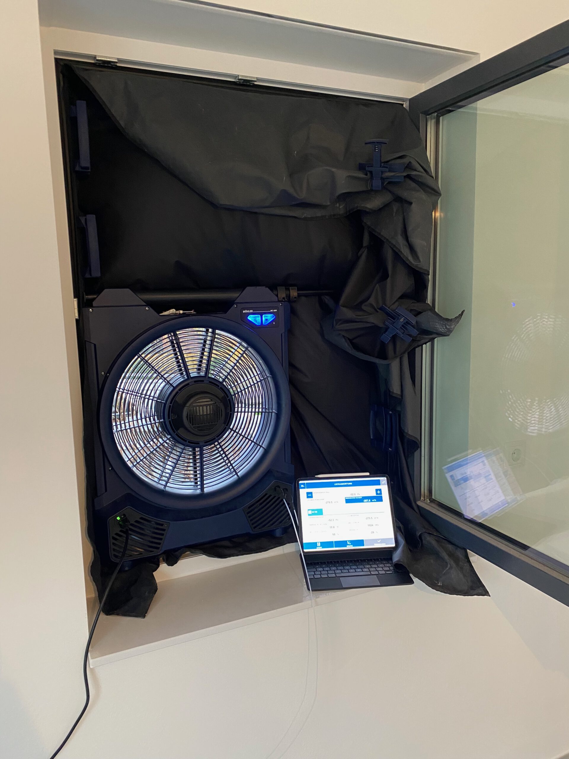 Professioneller Blower-Door-Test mit Messventilator und Laptop zur Luftdichtheitsmessung – Was kostet ein Blower-Door-Test?