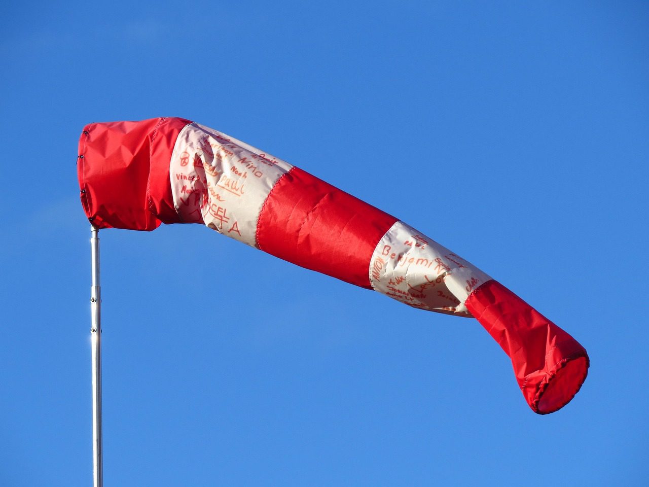 Windsack im Wind als Symbol für die Vorteile vom luftdichten Bauen und die Vermeidung von unkontrollierten Luftströmungen in Gebäuden.